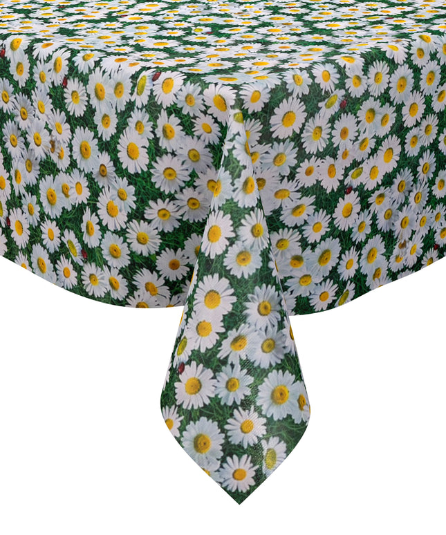 Rechteckige Wachstuch-Tischdecke mit dichtem Gänseblümchen-Muster. Zahlreiche weiße Blüten mit gelber Mitte bedecken einen grünen Hintergrund aus Blättern und Gräsern und erzeugen die Optik einer blühenden Sommerwiese. Zwischen den Blüten sind vereinzelt kleine Marienkäfer zu sehen, die dem floralen Design einen natürlichen und verspielten Akzent verleihen. Die Tischdecke fällt über die Kanten eines Tisches herab.
