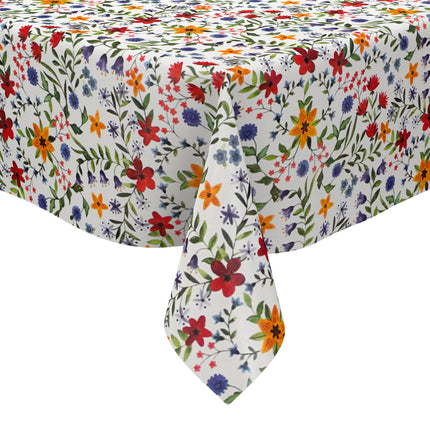 Weiße Wachstuch-Tischdecke mit dichtem, farbenfrohem Wildblumenmuster. Rote, gelbe, orangefarbene, blaue und violette Blüten sowie grüne Blätter und Ranken verteilen sich gleichmäßig über die gesamte Oberfläche und erinnern an eine blühende Sommerwiese im Landhausstil. Die rechteckige Tischdecke ist dekorativ über einen Tisch drapiert.