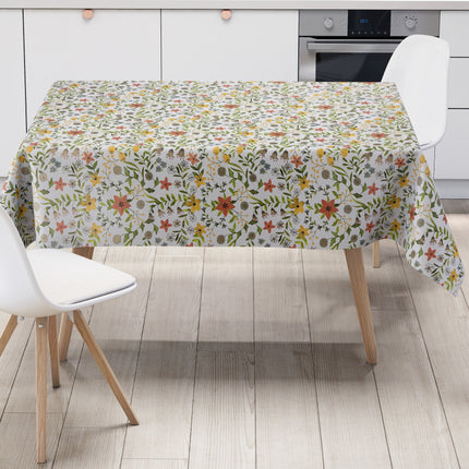 Weiße Wachstuch-Tischdecke mit zartem Blumenwiesen-Muster in Gelb, Apricot, Creme und Grau sowie grünen Blättern und Ranken in natürlicher Aquarell-Optik.