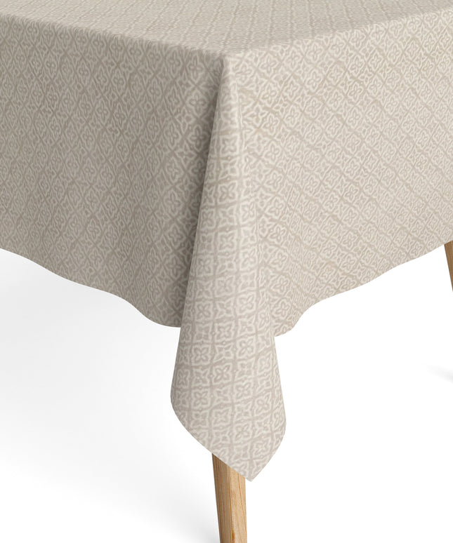 Jacquard-Tischdecke aus beschichteter Baumwolle mit Fleckenschutz, beige mit filigranem Rauten- und Blumenmuster, auf einem Holztisch drapiert.