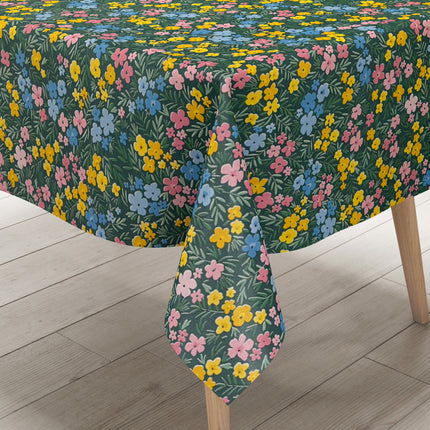 Dunkelgrüne Wachstuch-Tischdecke mit buntem Streublumenmuster aus kleinen gelben, rosa und blauen Blüten sowie feinen grünen Blättern, die über die gesamte Oberfläche verteilt sind.