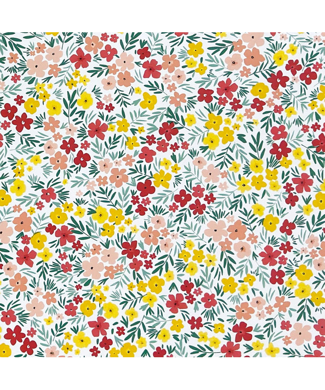 Bunte Wachstuch-Tischdecke mit dichtem Streublumenmuster in Rot, Gelb und Rosa sowie grünen Blättern auf hellem Hintergrund, über eine rechteckige Tischkante drapiert.