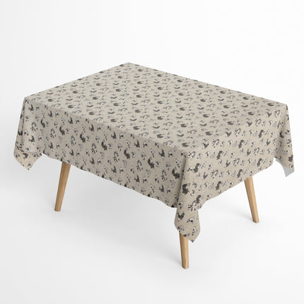 Beschichtete Baumwoll-Tischdecke mit Fleckenschutz im Design FILLOL, naturfarbener Hintergrund mit einem verspielten Allover-Muster aus stilisierten Hühnern und Küken in Schwarz- und Grautönen im skandinavischen Landhausstil.