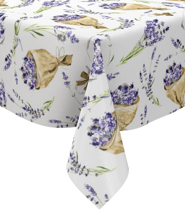 Wachstuch-Tischdecke mit Lavendelmuster auf hellem Hintergrund. Violette Lavendelzweige, kleine Sträuße und in Papier gewickelte Lavendelbouquets sind gleichmäßig verteilt und werden durch grüne Stiele sowie braune Details ergänzt.