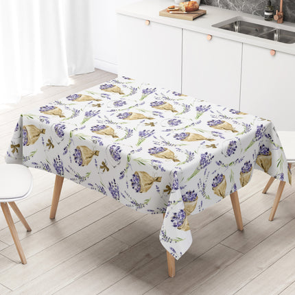 Wachstuch-Tischdecke mit Lavendelmuster auf hellem Hintergrund. Violette Lavendelzweige, kleine Sträuße und in Papier gewickelte Lavendelbouquets sind gleichmäßig verteilt und werden durch grüne Stiele sowie braune Details ergänzt.