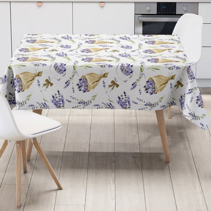 Wachstuch-Tischdecke mit Lavendelmuster auf hellem Hintergrund. Violette Lavendelzweige, kleine Sträuße und in Papier gewickelte Lavendelbouquets sind gleichmäßig verteilt und werden durch grüne Stiele sowie braune Details ergänzt.