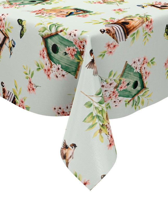Wachstuch-Tischdecke mit Vogelhäuschen, kleinen Vögeln, Schmetterlingen und rosa Blüten auf hellem mintfarbenem Hintergrund. Grüne Blätter und natürliche Holztöne verleihen dem verspielten Frühlingsdesign eine frische, freundliche Ausstrahlung.