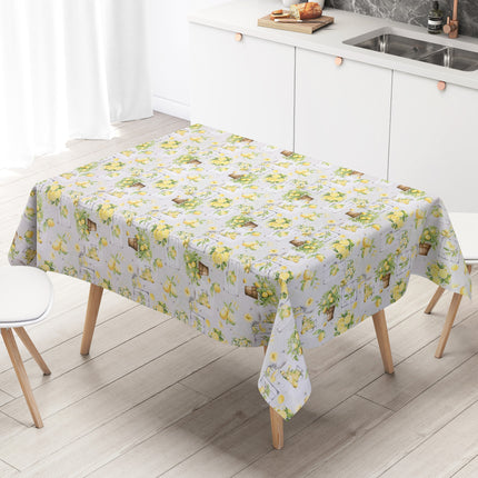 Wachstuch-Tischdecke mit mediterranem Zitronenmuster in Aquarelloptik. Gelbe Zitronen, grüne Blätter, Zitronenbäumchen in Terrakottatöpfen sowie rustikale Holzelemente und Gläser mit Zitronengetränken auf hellem Hintergrund