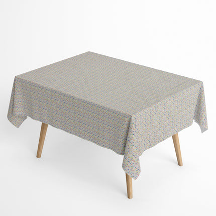 Jacquard-Tischdecke aus beschichteter Baumwolle mit hellem Grund und feinem, buntem Punktmuster in Blau, Rosa, Rot, Gelb, Grün, Orange und Violett.